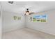 Bright bedroom with a ceiling fan, neutral carpet, and large windows bringing in natural light at 996 56Th S Ave, St Petersburg, FL 33705