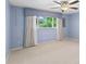 Cozy bedroom with blue walls, carpet, a ceiling fan and a large window at 996 56Th S Ave, St Petersburg, FL 33705