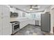 Bright kitchen featuring modern appliances, white cabinetry, and slate flooring at 996 56Th S Ave, St Petersburg, FL 33705