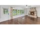 Bright living room with a stone fireplace, hardwood floors, and multiple windows at 996 56Th S Ave, St Petersburg, FL 33705