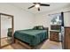 A bedroom is furnished with a bed, mirror and wood nightstand at 10401 Lakeside Vista Dr, Riverview, FL 33569