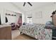 Bright bedroom with a floral comforter, ceiling fan, and a closet for ample storage at 10401 Lakeside Vista Dr, Riverview, FL 33569