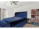A bedroom features blue furnishings, a bookcase and ceiling fan at 10401 Lakeside Vista Dr, Riverview, FL 33569
