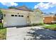 Home's exterior with a two-car garage, complemented by attractive landscaping at 10401 Lakeside Vista Dr, Riverview, FL 33569