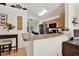 Efficient kitchen with wooden cabinetry, black appliances, and breakfast bar overlooking living area at 10401 Lakeside Vista Dr, Riverview, FL 33569