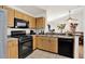 An open kitchen features wooden cabinets, black appliances and a tile floor at 10401 Lakeside Vista Dr, Riverview, FL 33569
