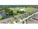 Aerial view of neighborhood showcasing location near a pond, schools, and tennis courts, surrounded by trees at 11526 Crowned Sparrow Ln, Tampa, FL 33626