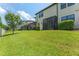Green lawn with landscaping extending to screened lanai and backyard fence at 11526 Crowned Sparrow Ln, Tampa, FL 33626