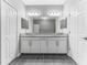 Bright bathroom with a double vanity with granite countertops, tile floors, and matching white cabinets at 11526 Crowned Sparrow Ln, Tampa, FL 33626