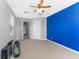 Bedroom featuring carpeting, windows, a fan, and an accent wall with views into the hall at 11526 Crowned Sparrow Ln, Tampa, FL 33626