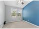 Bedroom with a large window, fan, and neutral carpet paired with an accent wall at 11526 Crowned Sparrow Ln, Tampa, FL 33626
