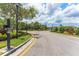 Well-maintained community entrance with lush landscaping, secure gate and mature trees on a bright, sunny day at 11526 Crowned Sparrow Ln, Tampa, FL 33626