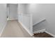 Upstairs hallway featuring carpet flooring and a white railing along the staircase at 11526 Crowned Sparrow Ln, Tampa, FL 33626
