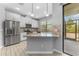 Modern kitchen with white cabinets, granite countertops, stainless steel appliances, and a view of the screened patio at 11526 Crowned Sparrow Ln, Tampa, FL 33626
