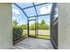 Screened lanai with tile flooring, screen walls, and views of backyard at 11526 Crowned Sparrow Ln, Tampa, FL 33626