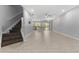 Bright and spacious living area with tile floors, stairs, and modern fixtures, flowing into a contemporary kitchen at 11526 Crowned Sparrow Ln, Tampa, FL 33626