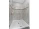 Modern walk-in shower featuring tiled walls, decorative trim, and a glass enclosure at 11526 Crowned Sparrow Ln, Tampa, FL 33626
