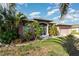 Charming single-story home with mature landscaping and decorative front door at 1162 Music Ln, North Port, FL 34286