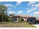 Charming single-story home with mature landscaping, a front lawn, and a decorative front door at 1162 Music Ln, North Port, FL 34286