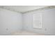 Simple bedroom with neutral walls, carpet, and a large window bringing in natural light at 11638 Branch Mooring Dr, Tampa, FL 33635