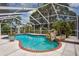 Inviting pool area featuring a rock waterfall, surrounded by lush landscaping and a screened enclosure at 11638 Branch Mooring Dr, Tampa, FL 33635