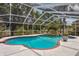 Relaxing pool area with a waterfall feature and a screened enclosure, perfect for outdoor enjoyment at 11638 Branch Mooring Dr, Tampa, FL 33635