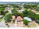 An aerial view of a charming single-story home featuring a classic red tile roof, surrounded by lush greenery in a vibrant neighborhood at 120 Bosphorous Ave, Tampa, FL 33606
