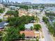 An aerial view displays a neighborhood showcasing the home with a classic red tile roof, in a well-treed area close to downtown at 120 Bosphorous Ave, Tampa, FL 33606