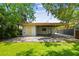 The backyard features a covered structure, a stone tile patio, and a well manicured lawn at 120 Bosphorous Ave, Tampa, FL 33606