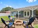 Inviting backyard featuring a covered patio with a fire pit, seating and a dining table at 12920 124Th Ave, Largo, FL 33774