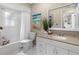 Bright bathroom featuring a white vanity, granite countertop and shower over tub at 12920 124Th Ave, Largo, FL 33774