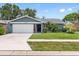 Beautiful single-story home with a lush front lawn, mature landscaping, and a two-car garage at 12920 124Th Ave, Largo, FL 33774