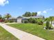 Well-maintained single-story home with a lush green lawn, mature trees, and landscaping at 12920 124Th Ave, Largo, FL 33774