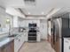 Modern kitchen featuring stainless steel appliances, granite counters, and white cabinets at 12920 124Th Ave, Largo, FL 33774