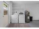 Bright laundry room featuring a washer, dryer, shelving, and water heater for efficient home maintenance at 12920 124Th Ave, Largo, FL 33774