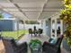 Covered patio features outdoor seating, a dining table, and views of the spacious backyard at 12920 124Th Ave, Largo, FL 33774