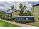 Exterior view of the building's facade featuring lush landscaping and a modern design against a backdrop of palm trees and blue skies at 1301 S Howard Ave # A22, Tampa, FL 33606