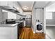 Efficient kitchen featuring stainless steel appliances, white cabinets, hardwood floors, and a convenient washer and dryer setup at 1301 S Howard Ave # A22, Tampa, FL 33606
