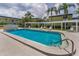 Community pool area with a trellis, lawn chairs, and shady palm trees at 1301 S Howard Ave # A22, Tampa, FL 33606