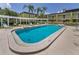 Community pool with lounge chairs and a trellis in a tropical setting at 1301 S Howard Ave # A22, Tampa, FL 33606