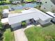 An aerial view reveals a well-maintained lawn, garden beds, driveway, and boat parking along canal front at 13928 Raie Ave, Hudson, FL 34667