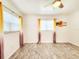 Cozy bedroom showcasing laminate flooring, neutral decor, and bright natural light at 13928 Raie Ave, Hudson, FL 34667
