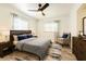 Comfortable bedroom with a ceiling fan, blue accents, and hardwood-style floors throughout at 13928 Raie Ave, Hudson, FL 34667