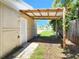 A view of the covered carport, featuring a wood frame and corrugated roofing, next to a beige building at 13928 Raie Ave, Hudson, FL 34667