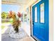 Charming home showcasing a bright blue front door and beautiful landscaping, offering a welcoming entrance at 13928 Raie Ave, Hudson, FL 34667