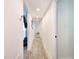 Long hallway featuring wood-look floors with access to other rooms and an entertainment space at 13928 Raie Ave, Hudson, FL 34667