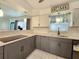 Updated kitchen featuring two-tone cabinetry, stone countertops, modern appliances, and stylish pendant lighting at 13928 Raie Ave, Hudson, FL 34667