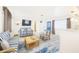 Cozy living room with blue-and-white striped furniture, a TV, and views of the kitchen at 13928 Raie Ave, Hudson, FL 34667