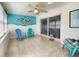 Bright sunroom with tile flooring, ceiling fan, sliding glass doors, and unique decor, perfect for relaxing at 13928 Raie Ave, Hudson, FL 34667