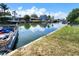 Scenic waterfront view showcasing a boat in the canal, lush green grass, and clear blue skies at 13928 Raie Ave, Hudson, FL 34667